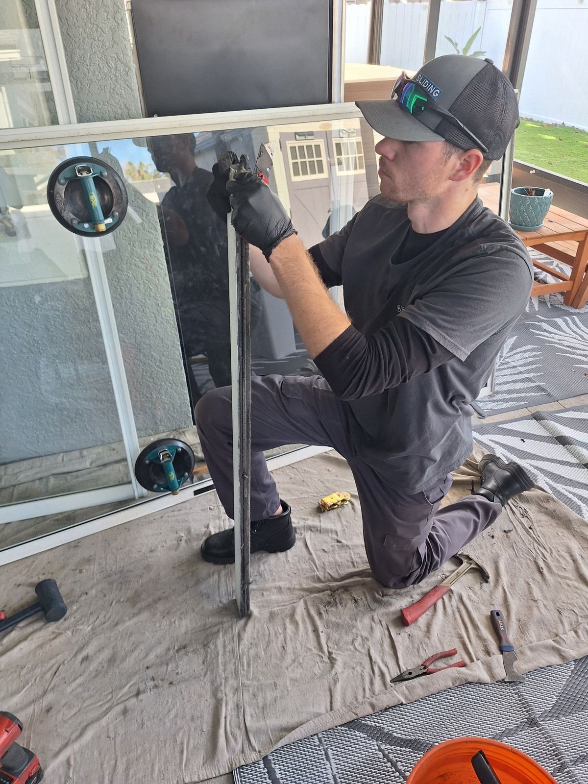 Technician replacing the rollers in a sliding glass door panel — sliding glass door repair in Deltona, Florida