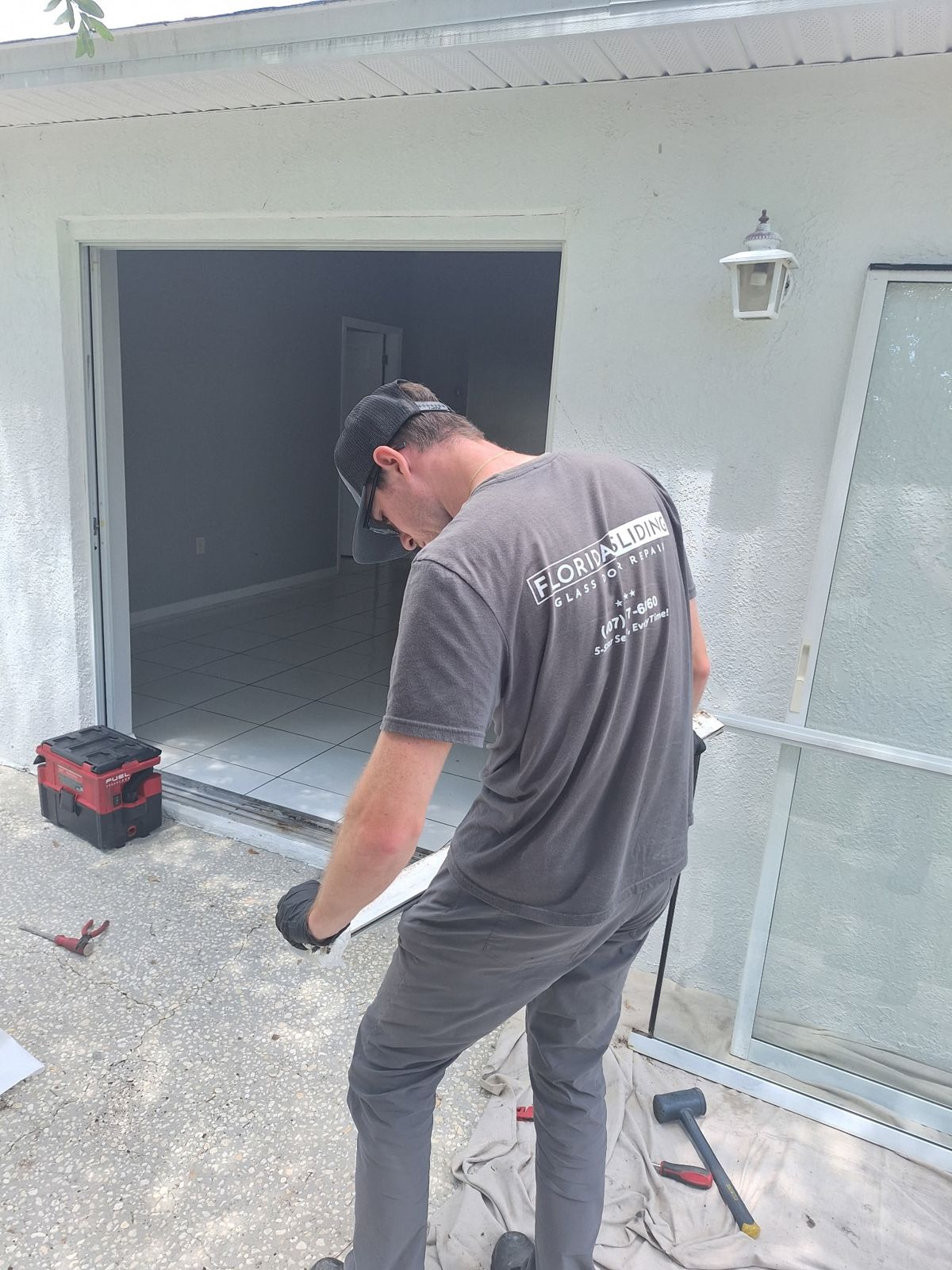 Technician preparing a sliding glass door opening in a garage bay — sliding glass door services in Windermere, Florida