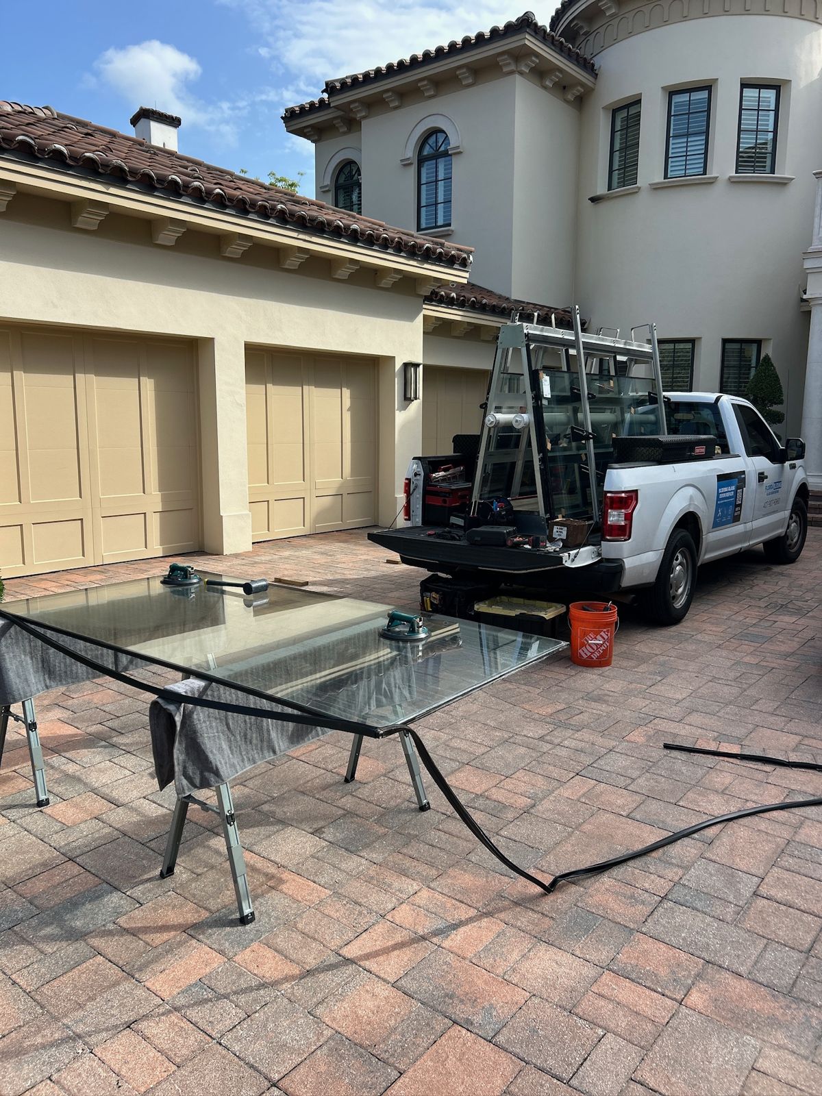 Replacement sliding door glass staged on a rack in a driveway — sliding glass door repair in Palm Bay, Florida