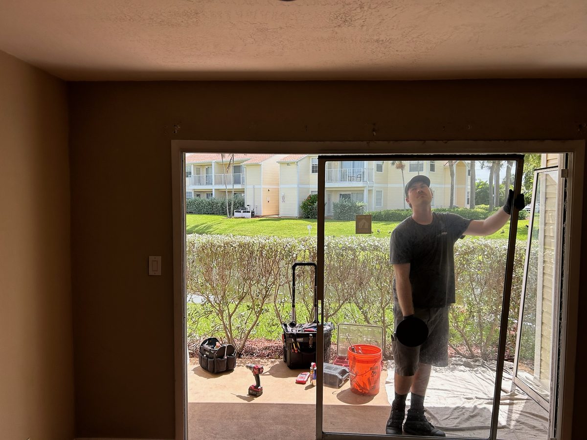 Technician replacing the SGD lock in a sliding glass door