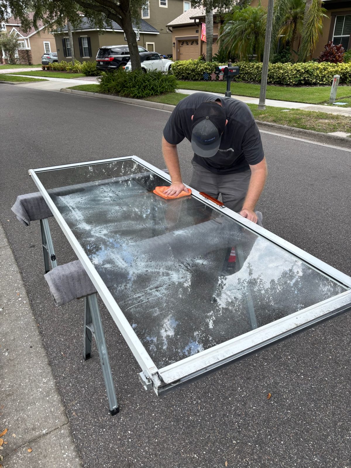 Technician preparing a replacement sliding door glass panel — sliding glass door repair in Melbourne Beach, Florida