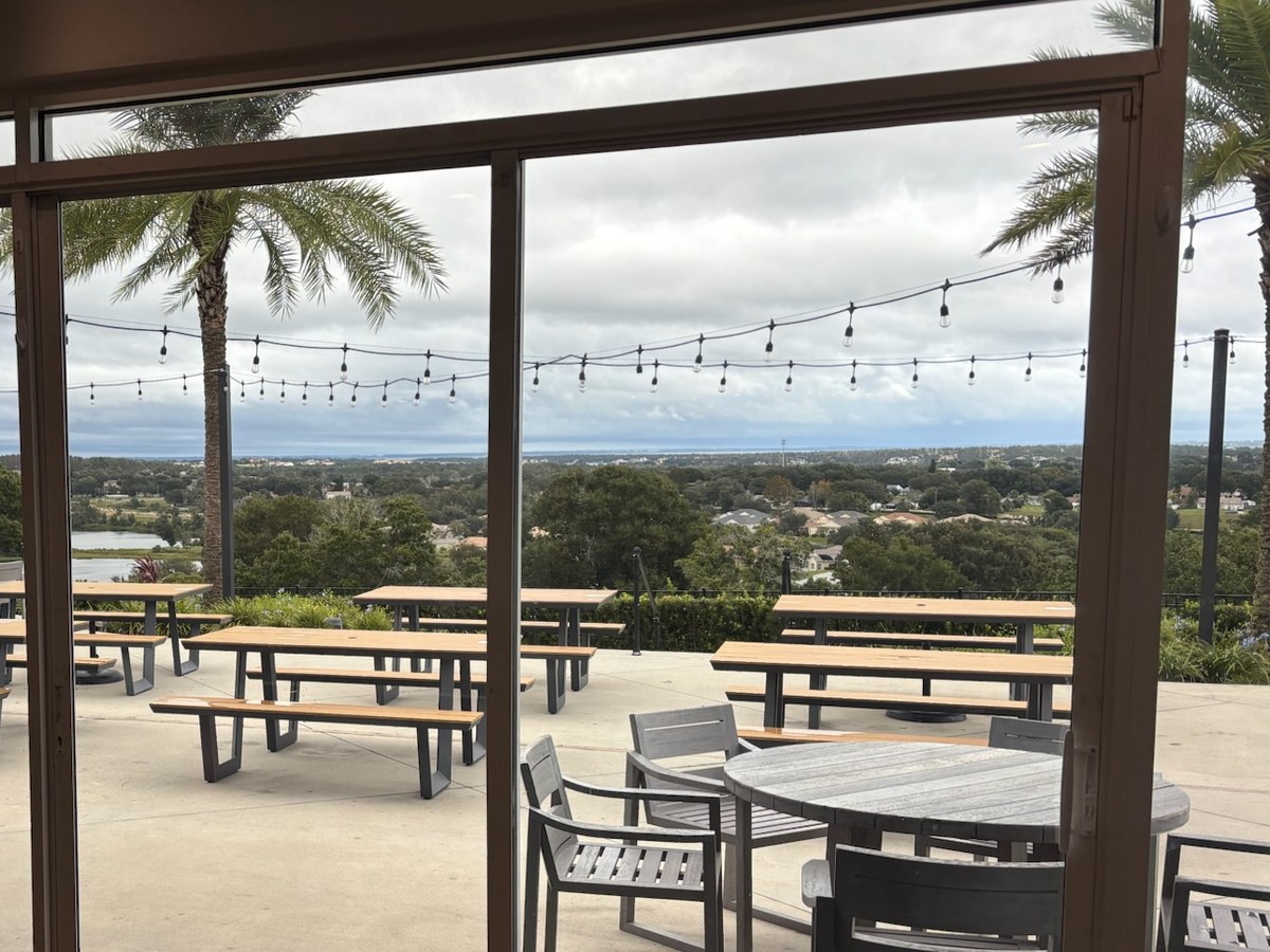 Multi-panel commercial sliding glass doors opening onto a covered clubhouse terrace at a Florida property